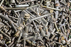 full frame background of used automobile bolts heap, old and dirty