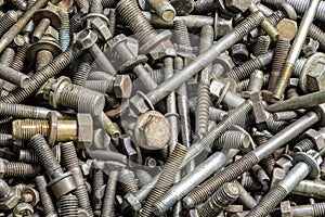 full frame background of used automobile bolts heap, old and dirty