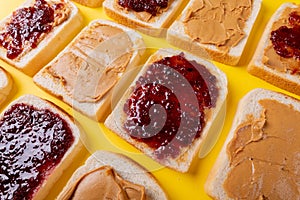 Full frame close-up of bread slices with preserves and peanut butter arranged alternatively
