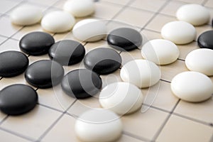 Full frame close up of go board with black and white stone pieces concept for intelligent strategy, difficulty games and