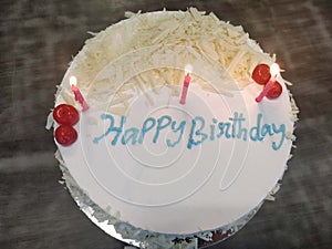 White birthday cake with lit candles