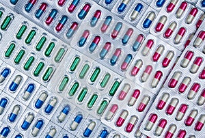 Full frame of colorful capsule pills in blister pack arranged with beautiful pattern. Pharmaceutical packaging.