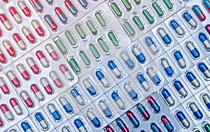 Full frame of colorful capsule pills in blister pack arranged with beautiful pattern. Pharmaceutical packaging. Medicine for infec