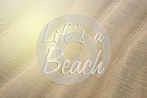 Full frame image of a beach sand with LIFE`S A BEACH word.