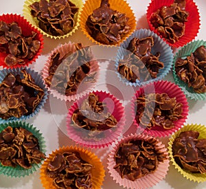 Full frame image of cornflake chocolate crispy cakes in coloured paper cases