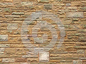 Full frame image of an old yellow sandstone wall made of regular blocks