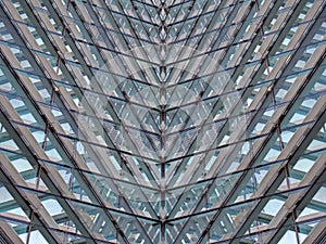 Full frame modern architectural abstract with futuristic geometric angular reflected shapes and lines in blue glass and steel