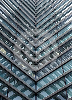 Full frame modern office architecture abstract with geometric angular reflected shapes and lines in blue glass windows