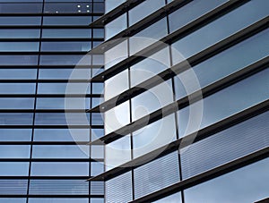 Full frame modern office architecture abstract with geometric shapes of tall buildings reflecting the blue sky in large glass