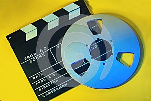 Full frame photo of a film board and a tape spool in a yellow background