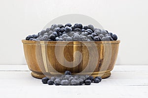 Full frame picture of wooden bowl full of farm fresh, big blueberries