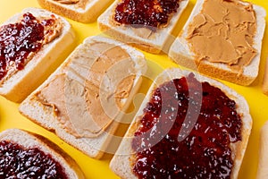 Full frame shot of bread slices with preserves and peanut butter arranged alternatively