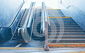 Full frame take of a stone staircase next to a modern escalator