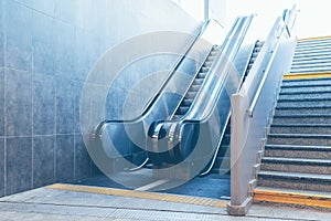 Full frame take of a stone staircase next to a modern escalator