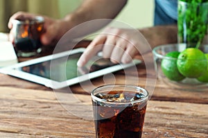 Full glass beaker of cola on a wooden table