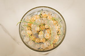 Full glass of currant/full glass of currant on a white marble background, top view