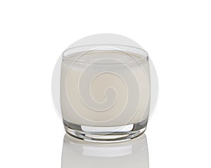 Full glass of fresh milk on white with reflection