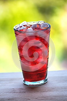 Full glass of water and juice with ice on the wooden kitchen counter.