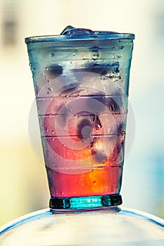 Full glass of water and juice with ice on the wooden kitchen counter.