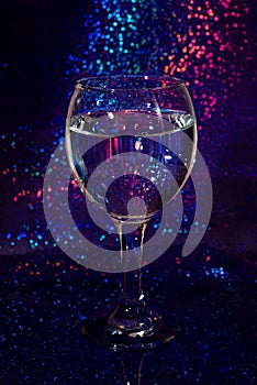Full glass of wine on a shiny background in a bar, vertical photo