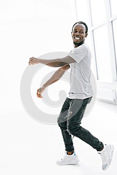 in full growth. a happy young man in a white t-shirt .