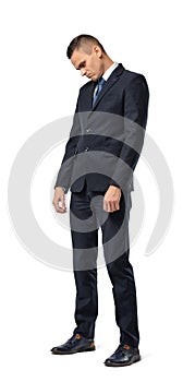 Full growth portrait of businessman standing with bowed head and looking sad isolated on white background