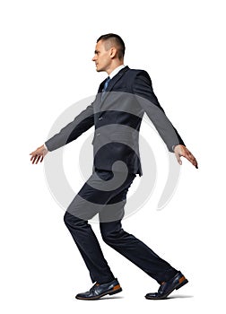 Full growth portrait of businessman walking tightrope isolated on white background