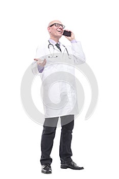 in full growth. smiling doctor with a smartphone.