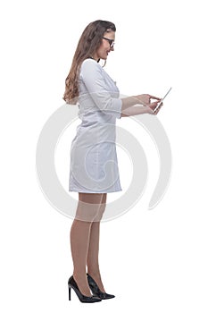 In full growth. smiling woman doctor using a digital tablet