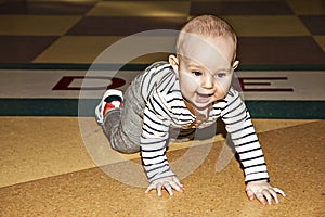 Full height portrait of a toddler. baby crawls on the floor. learning stage to walk.