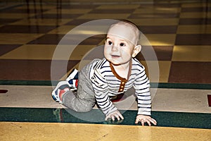 Full height portrait of a toddler. baby crawls on the floor. learning stage to walk.