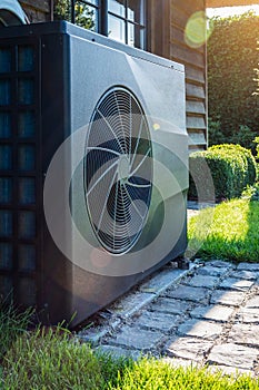 Full inverter heat pump near house in garden. Close-up.