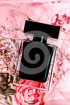 Full jar of perfume on pink background with water and flowers- Image