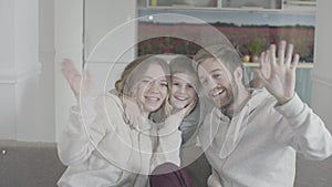 Full joyful happy family parents waving hands sitting on the couch