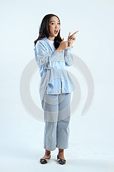 full leght shoot of happy asian Indonesian woman wearing casual attire, pointing finger on isolated background photo