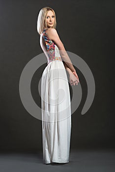 Full-lenght portrait of bnonde woman in white long dress