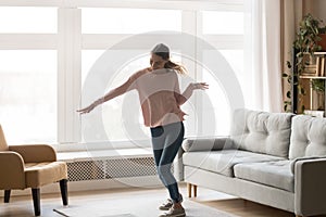 Full-length of active young woman dancing in living room
