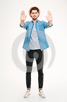Full length of angry man standing and showing stop gesture