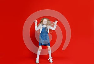 full-length attractive, cute, small, cheerful, cheerful girl, jumping,  red background