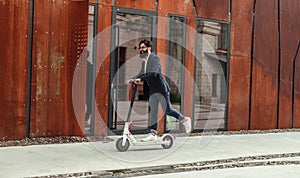 Happy hipster riding electric scooter