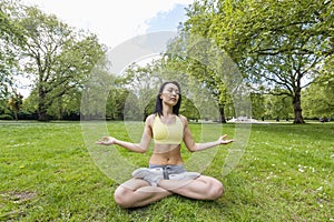 Full length of beautiful fit woman performing yoga at park