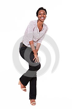 Full length beautiful young black woman leaning on white wall