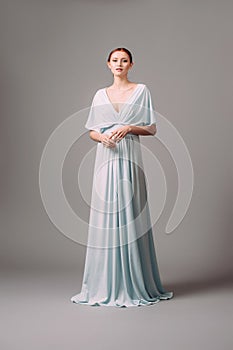 Full-length blue bridesmaid dress with flutter sleeves. Effortless festive summer look. photo