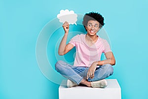 Full length body photo of youth smart guy hold paper bubble opinion cloud thoughtful sit white cube creative idea