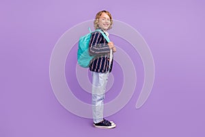 Full length body profile side size view of attractive cheerful boy going to school  over purple violet color