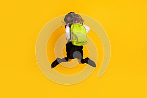 Full length body size back view photo schoolgirl jumping running to school isolated vibrant yellow color background