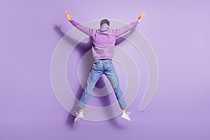 Full length body size photo back view man jumping up in hoody isolated pastel purple color background