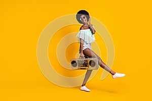 Full length body size photo of black skinned girl boombox touching hair wearing glasses isolated on bright yellow color