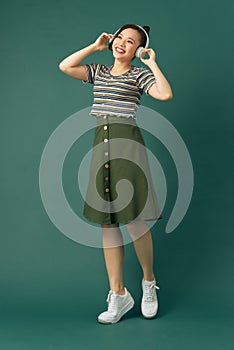 Full length body size photo of dancing girl imagining herself at disco while isolated with green background