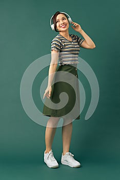 Full length body size photo of dancing girl imagining herself at disco while isolated with green background